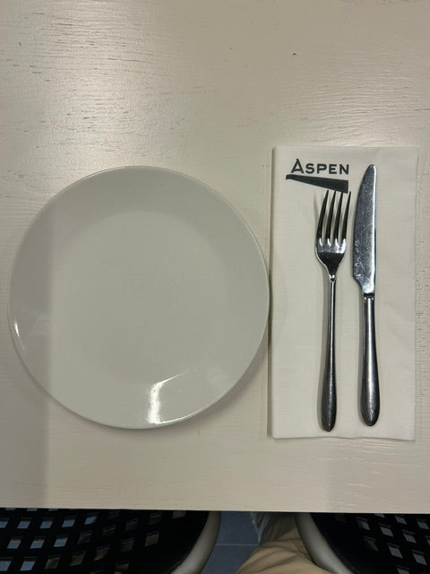 Bedrukte dinnerservet met logo Aspen naast bord en bestek